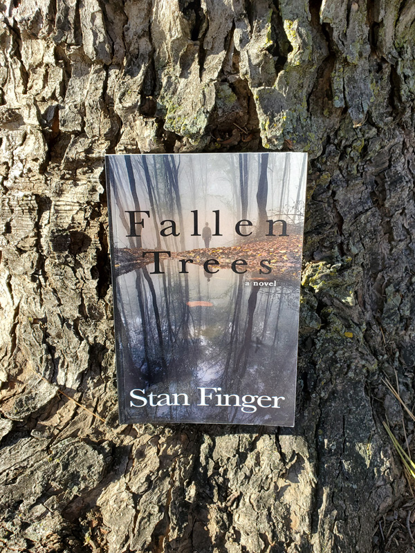 FALLEN TREES book propped on a tree in Riverside Park