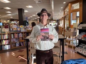 Author Stan Finger holding a copy of 105 Meadowlark Reader (Issue #6)